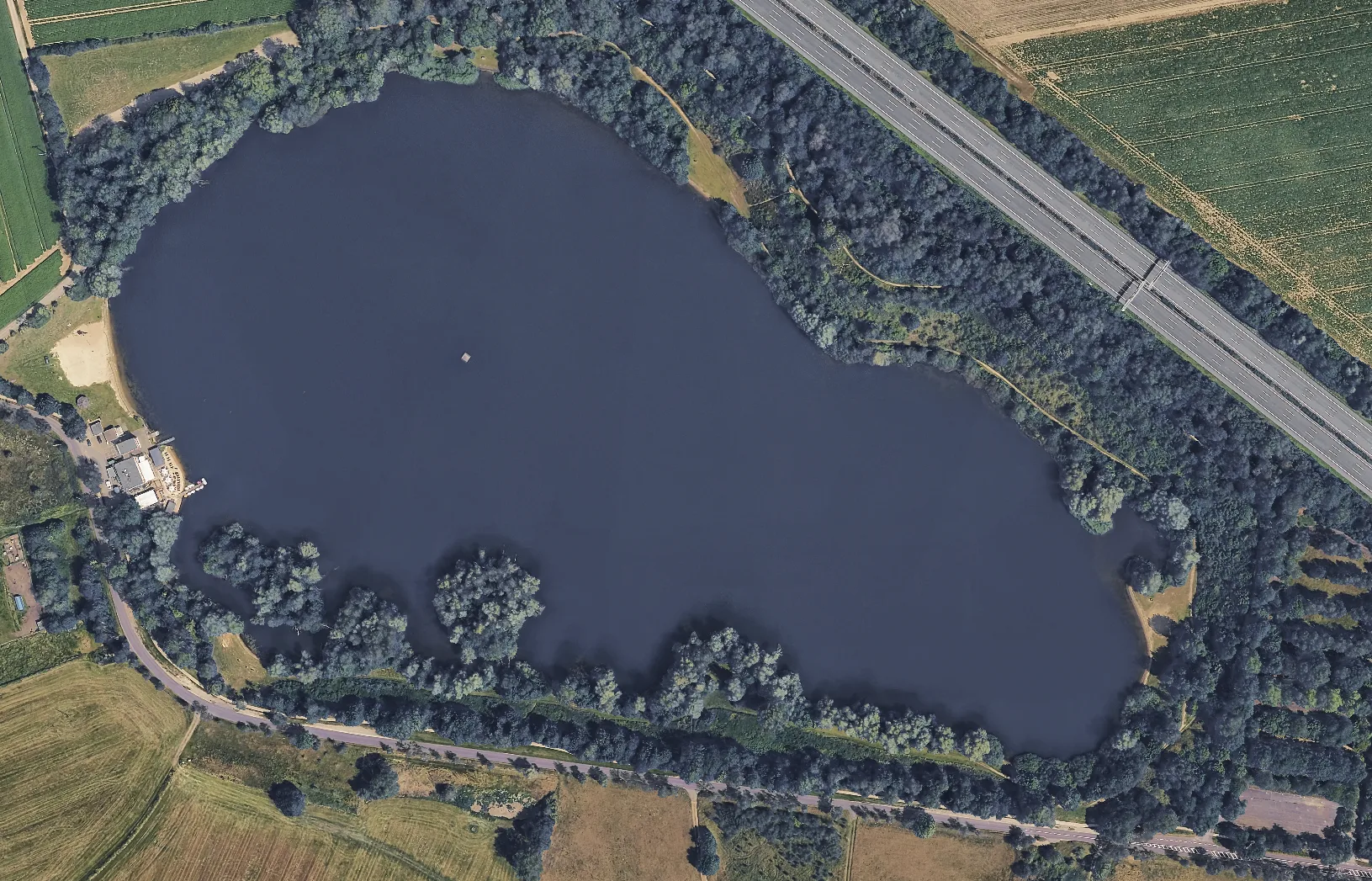 Luftaufnahme des Eixer Sees mit umliegenden Feldern und Wald
